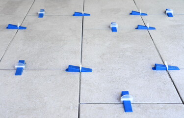 Tile leveling system with plastic clips and wedges, shot while the tile mortar sets