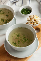 Homemade meaty broth with dill in bowls and crackers. The concept of healthy eating. Copy space.