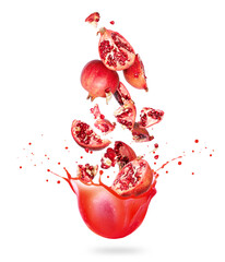 Whole and chopped pomegranate are falling in splashes of juice on a white background