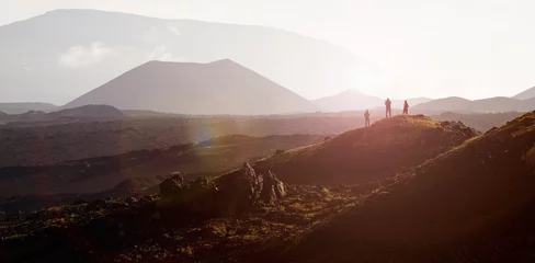 Fotobehang Chocoladebruin Beautiful landscape with mountains at sunrise with fog. Three people stand on a hill and look into the distance. Kamchatka  © kazantsevaov
