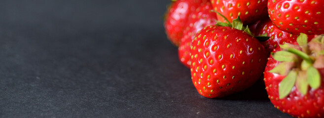 Strawberry ripe red sweet lies on a grey background with a copy space narrow photo