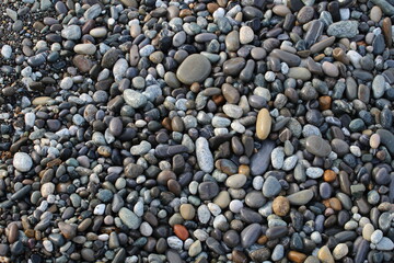 Grey black white brown pebbles stones on the beach background
