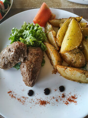 Home-style cutlets on a white plate with baked potato peasant
