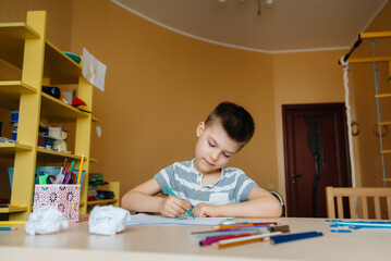 A school-age boy does homework at home. Training at school