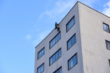 Bauarbeiter beim Abseilen an der Fassade eines Hochhauses 