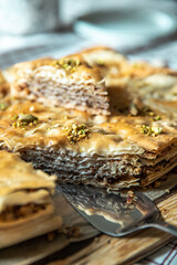 Homemade pistachio baklava triangles on wooden board.