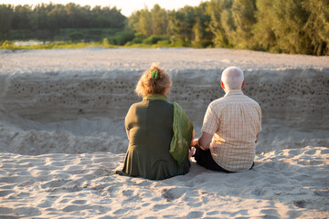 Senior couple sitting together in summer beach