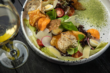 meat salad with vegetables, tomatoes, carrots on a white plate
