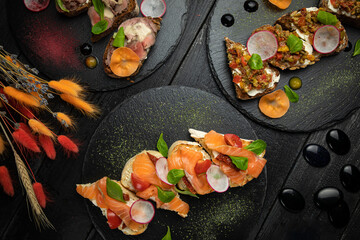 Italian bruschettas, with soft cheese and salmon, with meat and spices and vegetarian with tomatoes