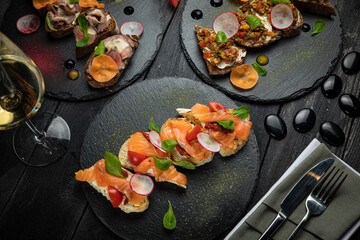 Italian bruschettas, with soft cheese and salmon, with meat and spices and vegetarian with tomatoes