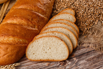 Close-up of homemade bread. Peasant loaf bread and wheat spikelets with space for text. Homemade...