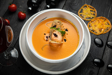 pumpkin soup with grilled salmon in a white plate. In the top restaurant
