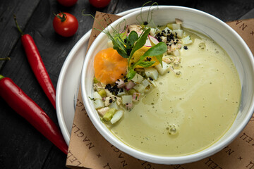 Top view of traditional Russian summer kefir or yogurt cold soup with vegetables called Okroshka. on a dark background