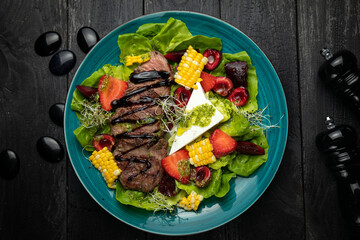 grilled veal with vegetables baked in a top premium restaurant. on a dark wooden table.
