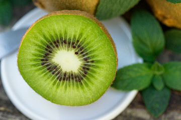 Fototapeta na wymiar Juicy fruits of kiwi and mint on a wooden background.