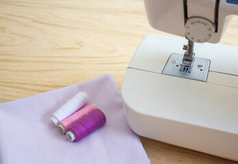 fabric and sewing threads are on the table next to the sewing machine