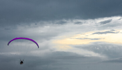 paraglider in the sky with upcoming storm in the background