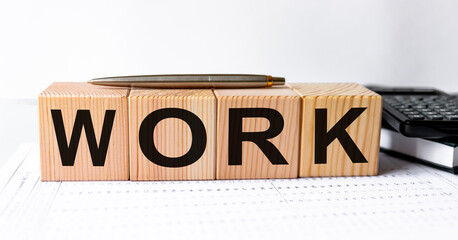 Concept word 'work' on wooden cubes with pen on a beautiful white background.