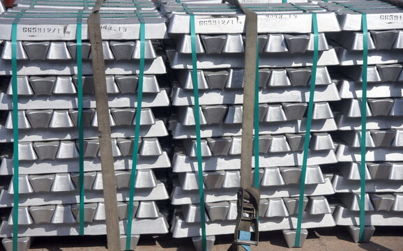 Gestapelte und mit Spanngurten gesicherte Zinkbarren