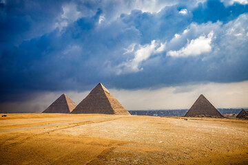 Pyramids of Giza with Cairo near by with dramatic clouds