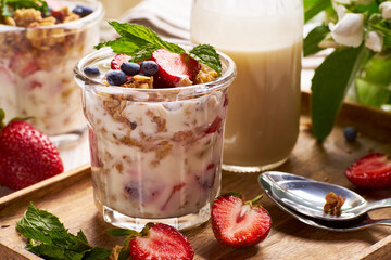 Glass cup of dessert with strawberries yogurt and granola