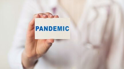 Doctor holding card with the text PANDEMIC