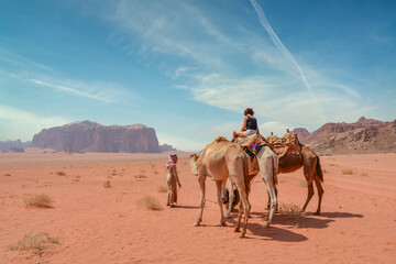 Female tourist riding a camel in the Wadi Rum desert
