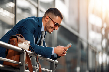 Attractive young businessman using a smart phone.