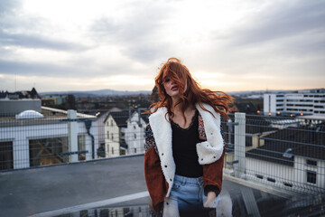Photo of beautiful millennial girl standing on lookout terrace. Attractive female model with face...