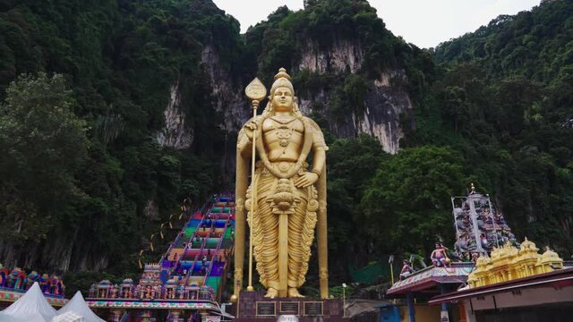 Indian temple in Batu caves near Kuala lumpur. In front of the temple is a golden statue and after climbing colorful stairs you reach the inside of the temple.