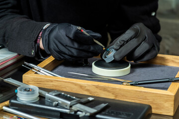 watch repair by a watchmaker; analysis of watches is shot in close-up in macro