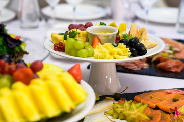 cheese plate with grapes on a table in a restaurant, cold snacks at a reception
