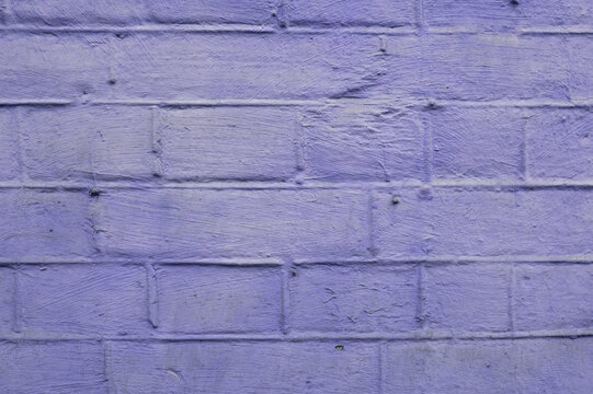 purple painted brick wall photographed perpendicularly close up
