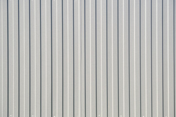 Gray corrugated metal fence on a sunny day..Corrugated surface seamless pattern.