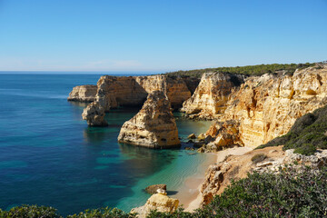 Fototapeta na wymiar popular Marinha Beach beach with typical rock formations such as natural bridges and arches in the Algarve