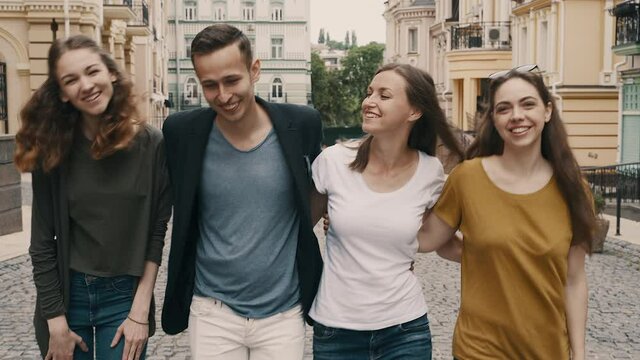 Group of young happy friends walking in the European city