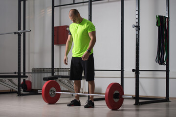 Fototapeta na wymiar Trainer In The Gym Exercising Back With Barbell