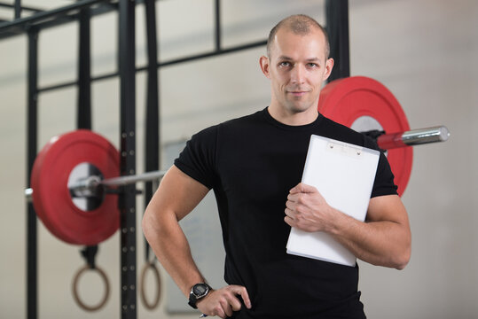 Personal Trainer Takes Notes On Clipboard