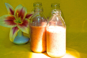 Glass bottles filled with colorful fresh homemade strawberry smoothies
