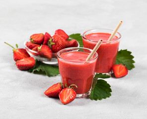 Strawberry smoothie in a jar with straws on a light background