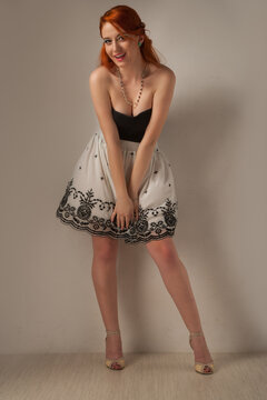 redhead girl posing looking cheerful isolated on light beige