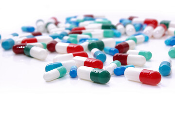 Medical pills in red, blue, green and other colors. Loose tablets on white surface. Health and medicine