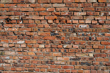 old brick wall, red building, old blackened stone falls off from old age