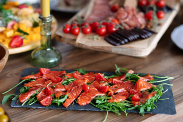 dish of red fish lies on  table, against  background of vegetables, selective focus, beautiful food,