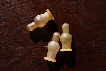 rubber pacifiers for feeding the baby with a mixture, three things lie on a brown table, signs of...