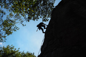 Silhouette of a rock climber and the blue sky