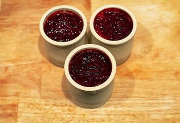 Homemade cheese cake with red fruit jam made in ceramic jars