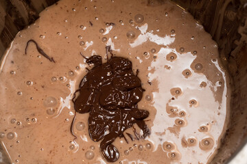 Mixing the necessary ingredients to make a chocolate cake ready to be beaten