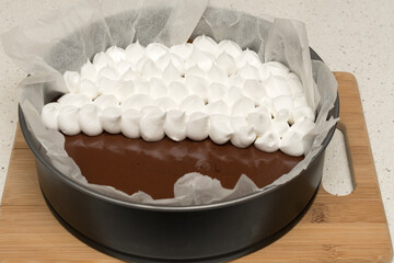 Mixing a chocolate cake with a piece of meringue