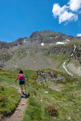 girl practicing mountain hiking in spring with a small river in the background in the Pyrenees